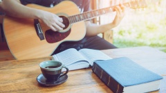 Gitarrenspieler mit Gesangbuch und Bibel