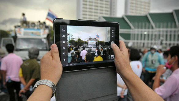 Ein Mann fotografiert mit einem iPad.