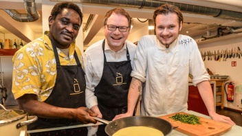 Koch Hassan Abakar Omar aus dem Sudan (li), Restaurantkritiker Robert Kroth (mi) und Sternekoch Tony Hohlfeld (re) backen im Küchenstudio "Geschmacksverstärker" in Hannover gemeinsam Fladen aus Hartweizengriess.