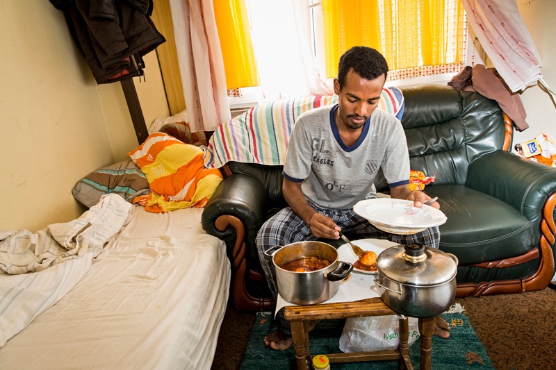 Omar hat sich etwas gekocht und isst in seinem Zimmer in der Flüchtlingsunterkunft Langschoss in der Nähe von Simmerath.