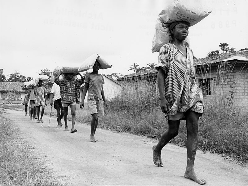 Menschen tragen Hilfsgüter ion Säcken auf dem Kopf in Nigeria