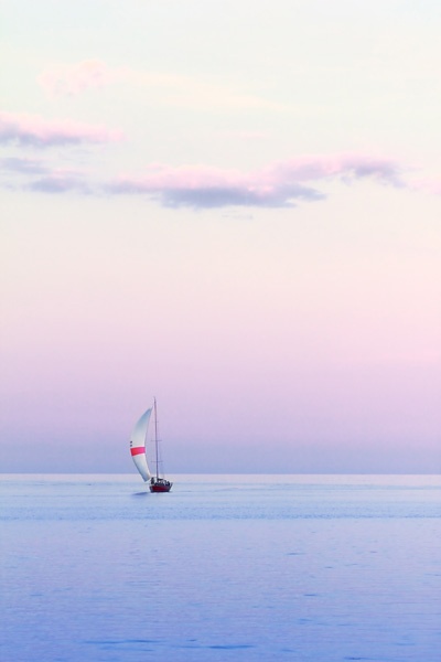 Ein Segelboot im Abendlicht auf dem Wasser.