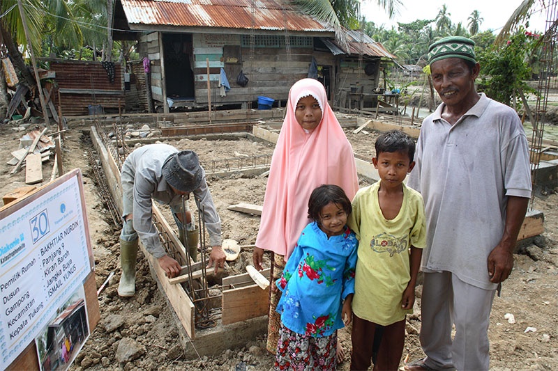 Familie vor ihrem Haus in Indonesien