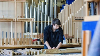 Ein Auszubildender zum Orgelbauer in der Orgelbaufirma Johannes Klais in Bonn verpackt eine neue Orgel der Christuskirche in Lima, Peru.