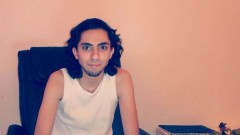 Porträt von Raif Badawi an einem Schreibtisch.