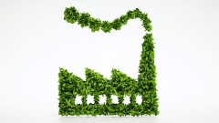 Symbolfoto Nachhaltigkeit und Klimaschutz: Grüne Blätter formen einen Fabrikgebäude.