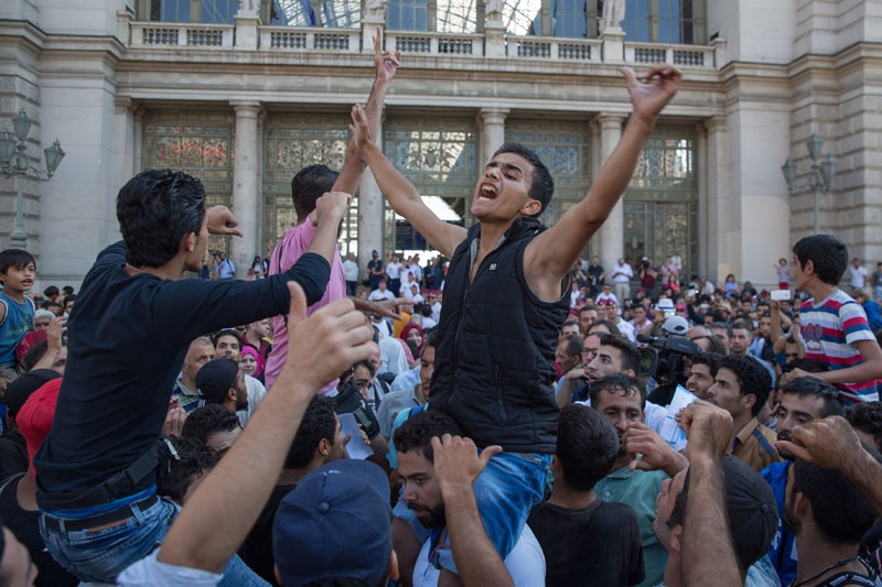 "Germany! Germany!", rufen verzweifelte Flüchtlinge vor dem Bahnhof. Die Ankündigung, dass die deutsche Bundesregierung keine syrischen Flüchtlinge in andere EU-Länder abschieben will, gab vielen von ihnen Hoffnung.