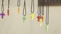 Kreuze in verschiedenen Farben an Lederbändern zum Umhängen.