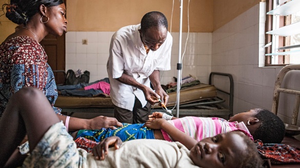 Dr.  Lantamer, Arzt in Baguida (Togo), gibt einem Kind eine Infusion gegen Malaria. 