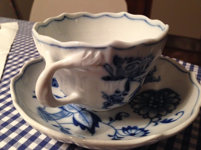 weißblaue Tasse auf weißblauer Tischdecke