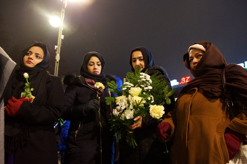 Muslimische Frauen mit Blumen stehen am Dienstagabend (20.12.16) vor der Berliner Kaiser-Wilhelm-Gedächtnis-Kirche