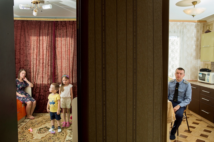 Mann in Uniform mit Familie in kleiner Wohnung