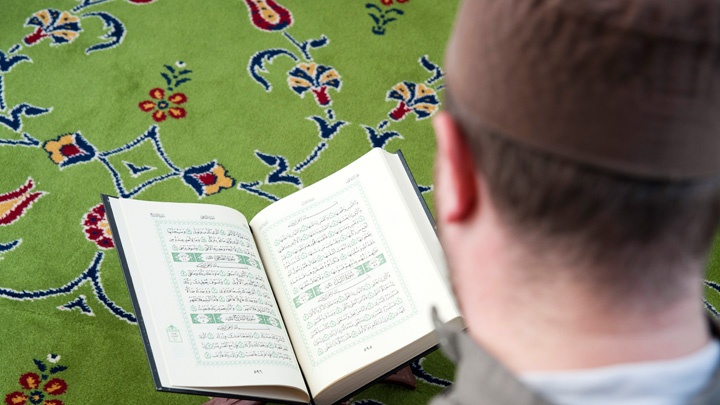 Ein Muslim liest in der Neuen Moschee in Berlin Kreuzberg im Koran.
