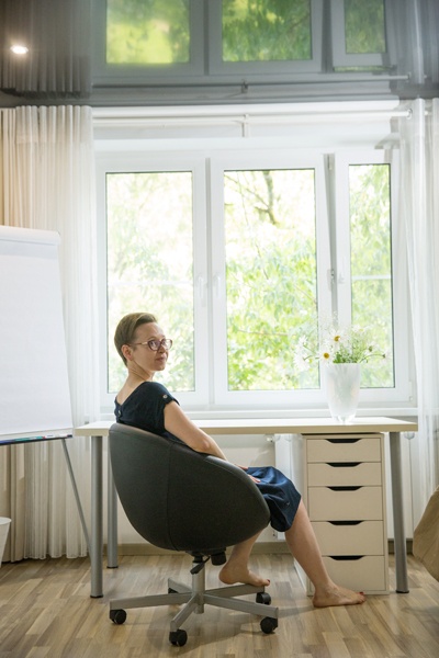 Kurzhaarige Frau an Schreibtisch vor Fenster